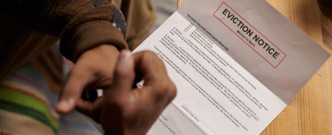 Person reading eviction notice on a wooden table related to tenant rights and eviction laws in Texas