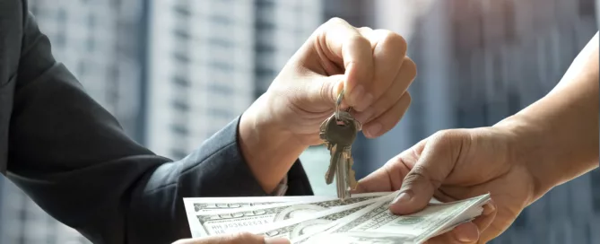 Hands exchanging house keys and cash, symbolizing a rental security deposit transaction.
